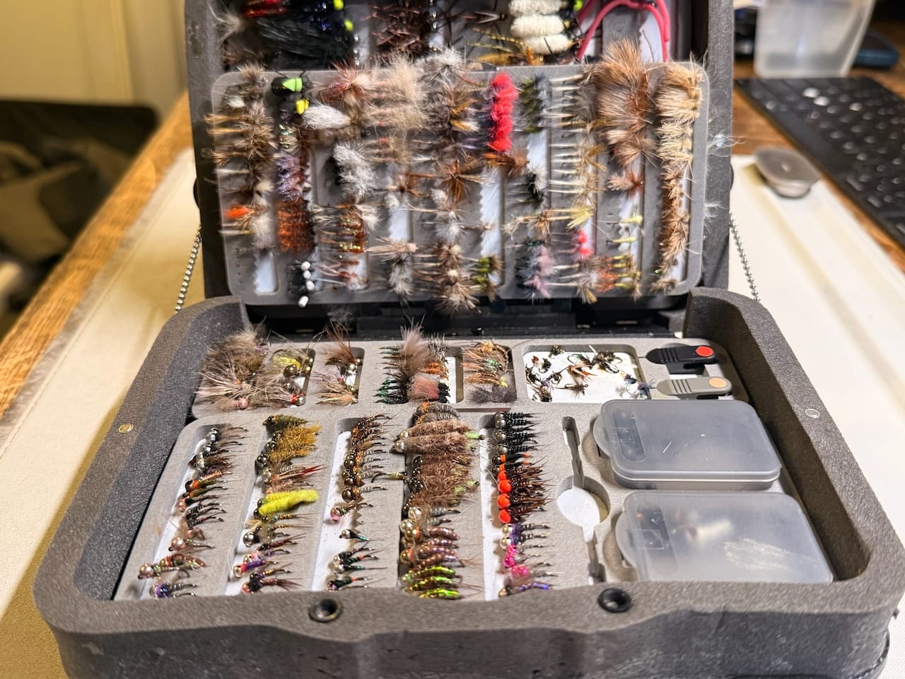 Open large C&F Design fly fishing chest pack with hundreds of nymphs, dry flies, and streamers