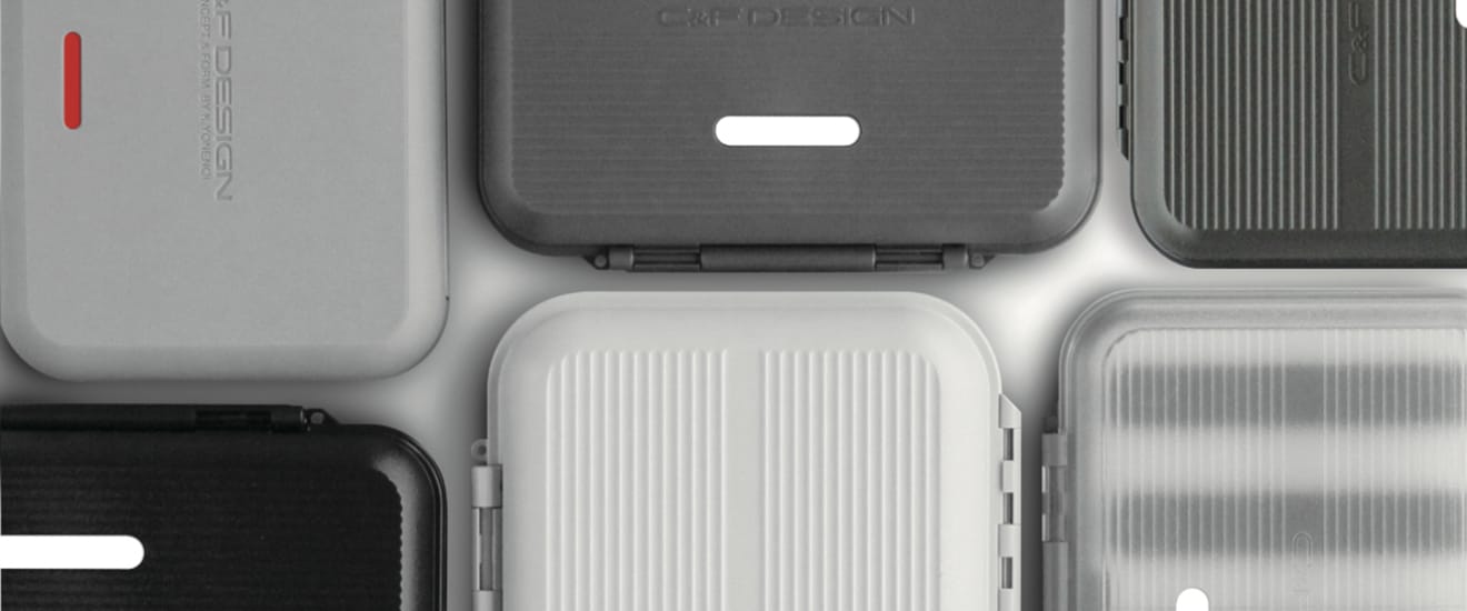 Overhead view of C&F Design fly boxes in black, gray, white, and clear arranged in a grid